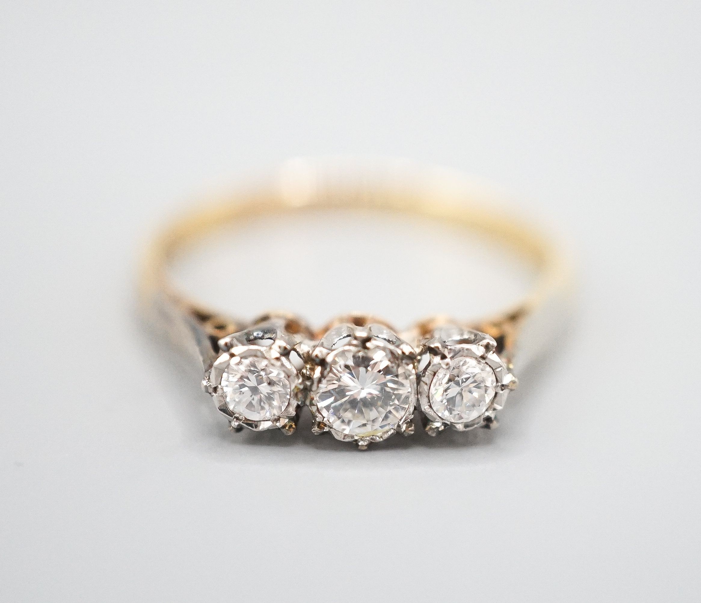 A modern 18ct gold and three stone diamond ring, size Q/R, gross weight 3 grams.